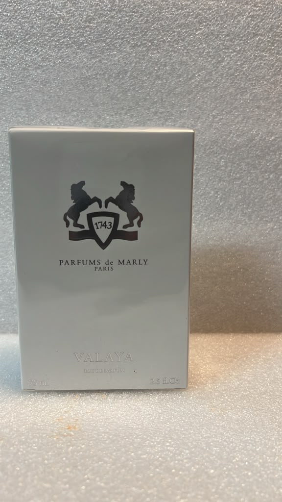 A rectangular silver-gray box for Parfums de Marly Valenza perfume, featuring a black crest logo with two horses and the text 'PARFUMS de MARLY PARIS' and 'VALENCIA' on a textured light background.